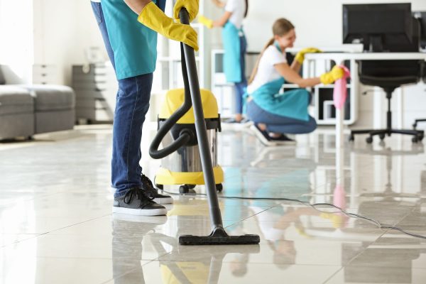 Janitor hoovering floor in office Janitor hoovering floor in office